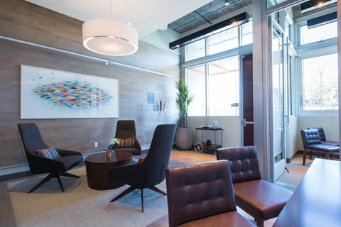 Modern lounge area with seating and large windows at View Point Apartments, Berkeley, California