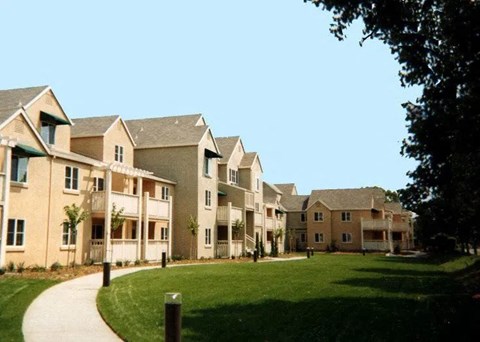 A row of houses with a green lawn in front.