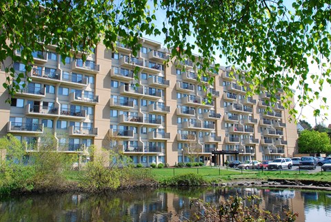 A large building with many windows is reflected in the water.