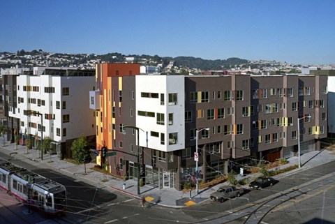 A street view of a city with a tram and apartment buildings.