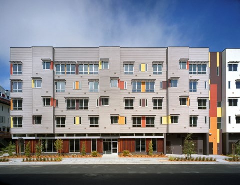 A modern apartment building with grey and orange accents.