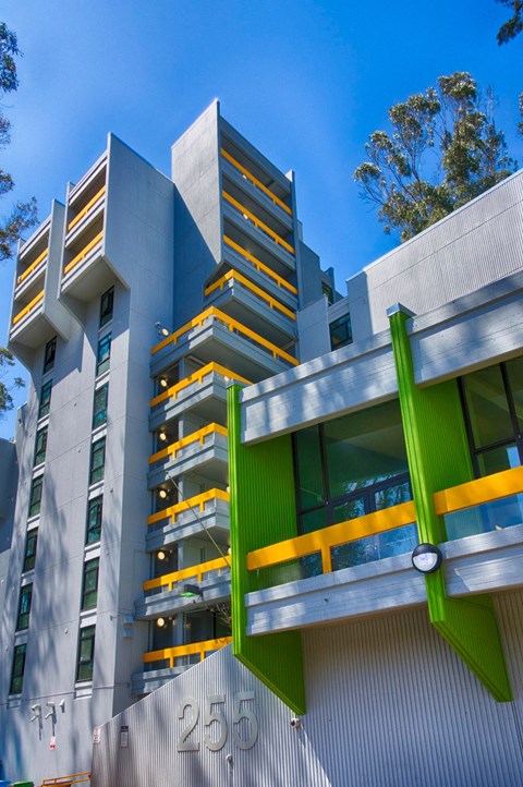 A modern building with a green and yellow balcony.