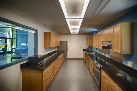 A kitchen with wooden cabinets and black countertops.