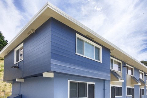 A blue house with white trim and windows.