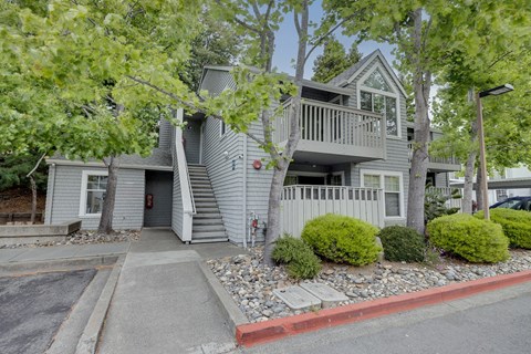 A house with a grey facade and a balcony.