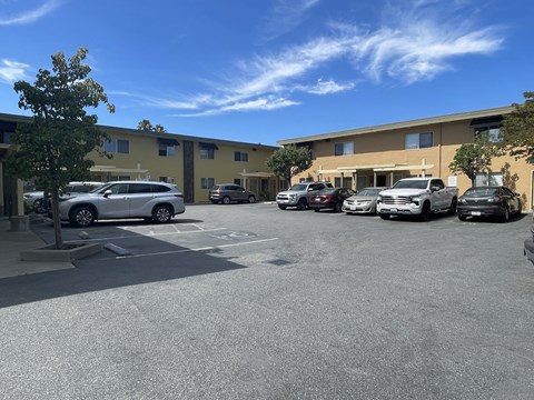 A parking lot with cars and a building in the background.