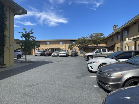 A parking lot with cars parked in front of a building.