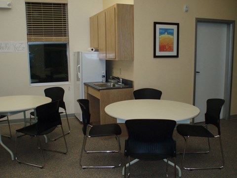 A kitchen area with a table and chairs.