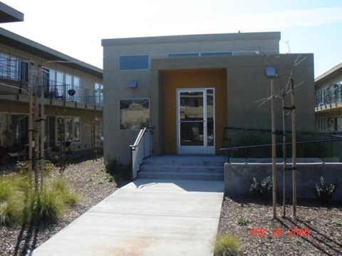 A modern building with a concrete facade and a yellow door.