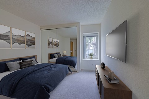 A bedroom with two beds and a flat screen TV mounted on the wall.