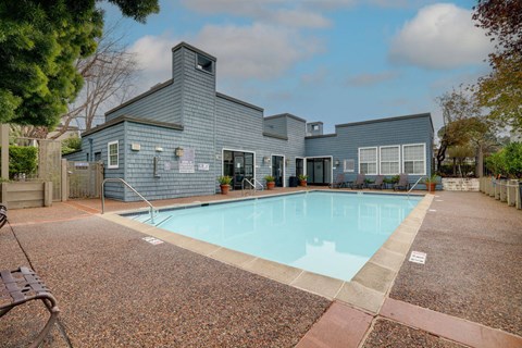 A pool in front of a grey building.
