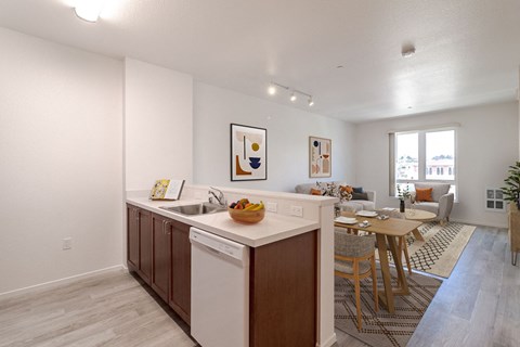 A kitchen with a white dishwasher and brown cabinets.