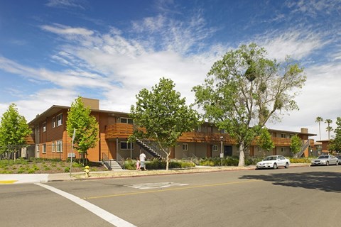 A large building with a brown roof and a tree in front of it.