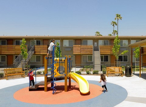 A playground with a yellow slide and a red and blue climbing frame.
