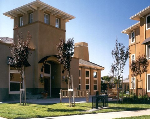 A building with a tower and a bench in front of it.