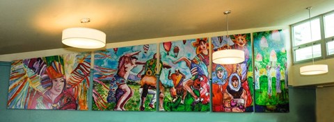 A wall of paintings depicting people in various poses.