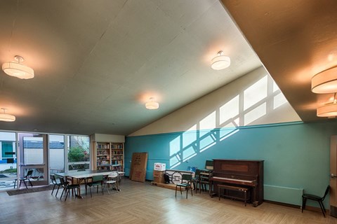 A room with a piano and a table with chairs.