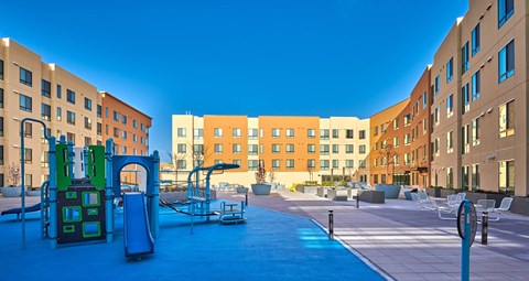 A playground area in front of apartment buildings.