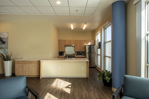 A kitchen area with a refrigerator, sink, and cabinets.