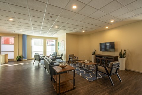 A living room with a couch, chairs, and a television.