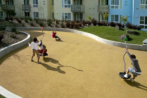Children playing on a playground with a yellow surface.