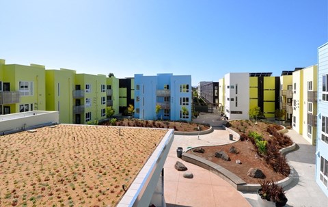 A series of colorful buildings with a small garden in front.