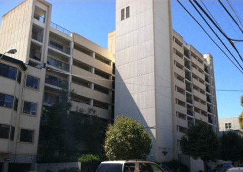 A white building with a car parked in front.