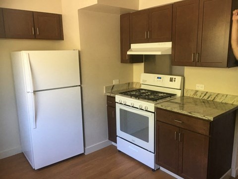 A kitchen with a white fridge and a white stove.