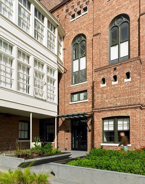 A red brick building with a white building attached to it.