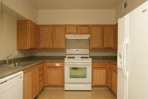 A kitchen with wooden cabinets and a white refrigerator.