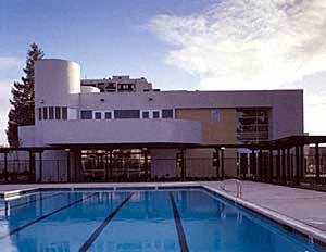 A swimming pool in front of a modern building.