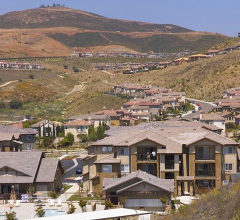 A residential area with houses and a mountain in the background.