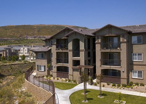 Apartment complex with a walkway and greenery.