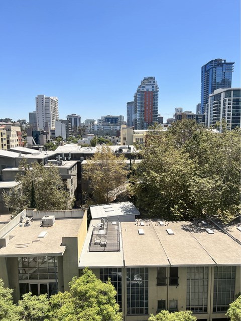 A cityscape with buildings and trees in the foreground.