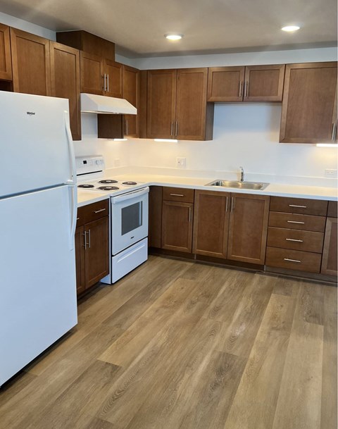 A kitchen with wooden cabinets and a white fridge.