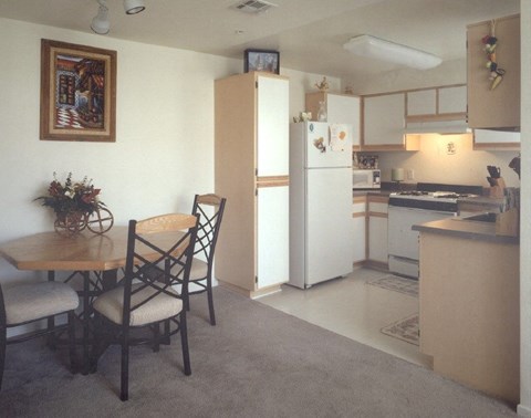 A kitchen with a table and chairs in it.