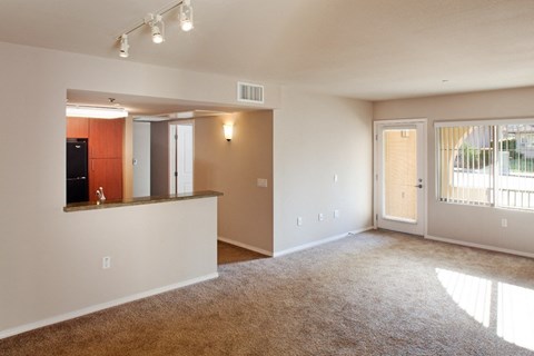 A spacious living room with a bar area and sliding glass doors.