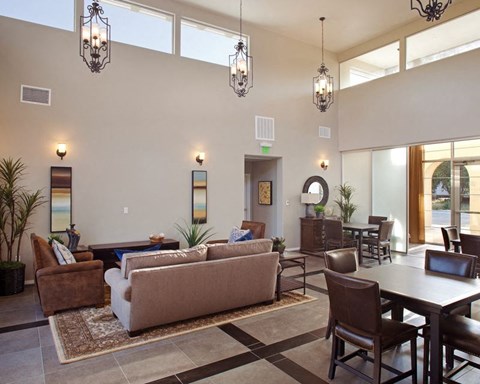 A living room with a brown couch, a coffee table, and a dining table.