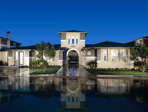 A house numbered 13875 is reflected in the water in front of it.