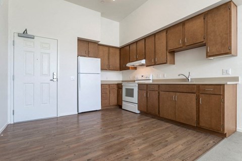 A kitchen with wooden cabinets and a white fridge.