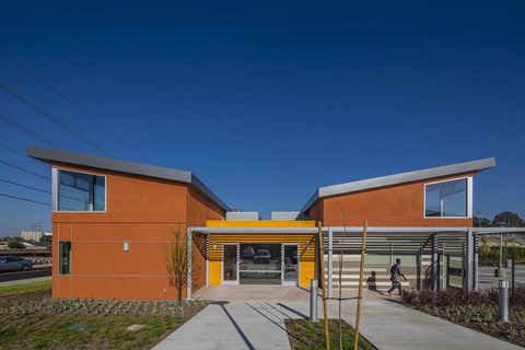 A modern building with orange walls and a yellow entrance.