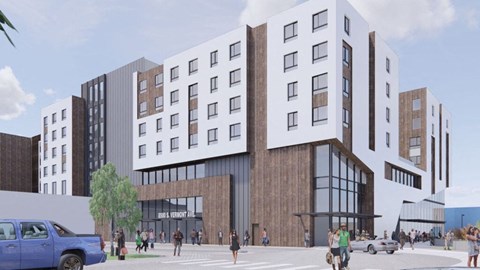 A modern building with a lot of windows and people walking around in front.