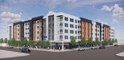 A modern multi-story apartment building with cars parked in front.