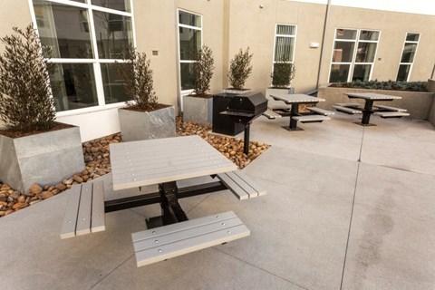 A concrete patio with a table and benches.