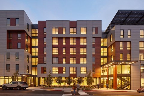 A modern multi-story building with a mix of red and white exterior.