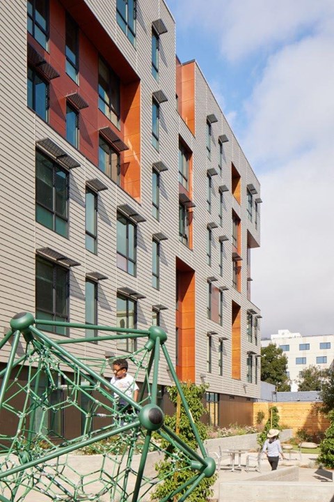 A modern building with a green metal structure in front.