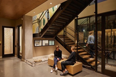 Two people sitting on a bench in a modern interior space.