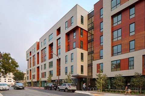 A modern apartment building with cars parked in front.