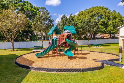 A playground with a green slide and a red and white slide at Academy on Dean Woods Apartments, Orlando, 32825