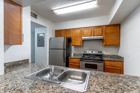 A kitchen with granite countertops and stainless steel appliances.